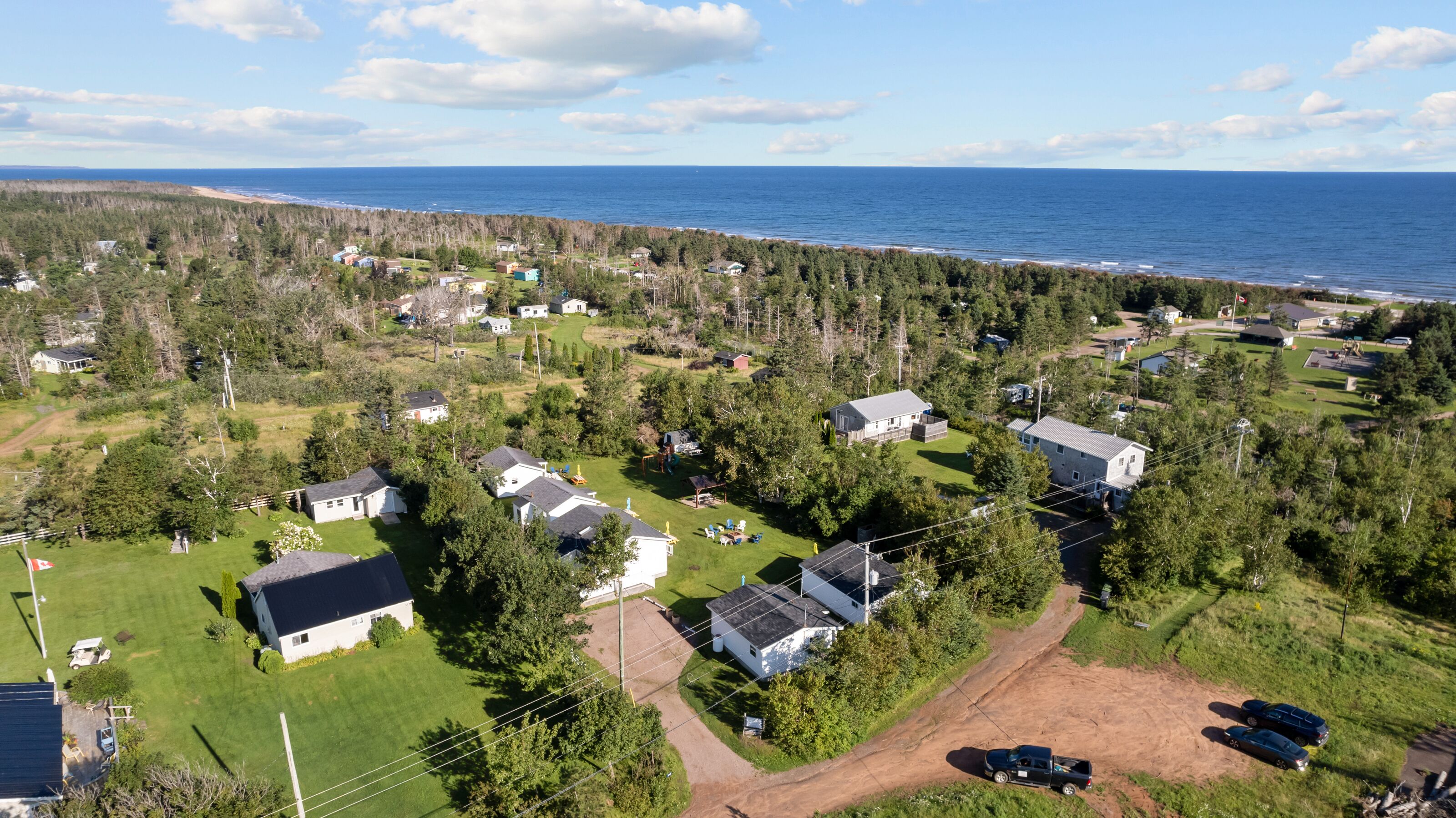 Una vista aerea di una zona residenziale con case, una spiaggia e un paesaggio boscoso.