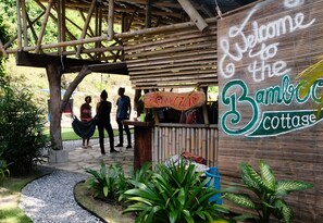 A reception area with a wooden structure, a sign reading "Welcome to the Bamboo Cottage," and a pathway leading to it. - Bamboo Cottage Langkawi (Langkawi)