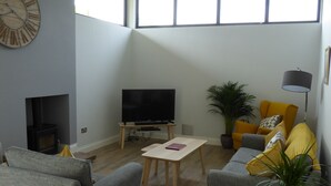 A living room with a TV, sofa, chairs, and a table. - Oak Lodge (Auchendennan) - sleeps 4 guests  in 2 bedrooms (Alexandria)