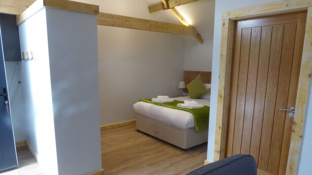 Ein Schlafzimmer mit einem Bett, einer Holztür und einem Sofa.