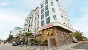 Un hotel de varios pisos con un cartel llamativo para Sunshine Apartment Hotel.