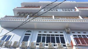 A multi-story building with balconies and air conditioning units. - Hotel O Pondok Bintang (Kendari)