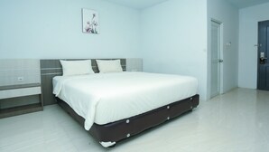 A modern bedroom with a large bed, a bedside table, and a door. - OYO 93774 Khaira Kos Dan PenginapanNearYani Heahlerr (Marabahan)