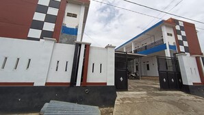 A gated building with a blue and white facade, a covered entrance, and a motorcycle parked inside. - OYO 93774 Khaira Kos Dan PenginapanNearYani Heahlerr (Marabahan)