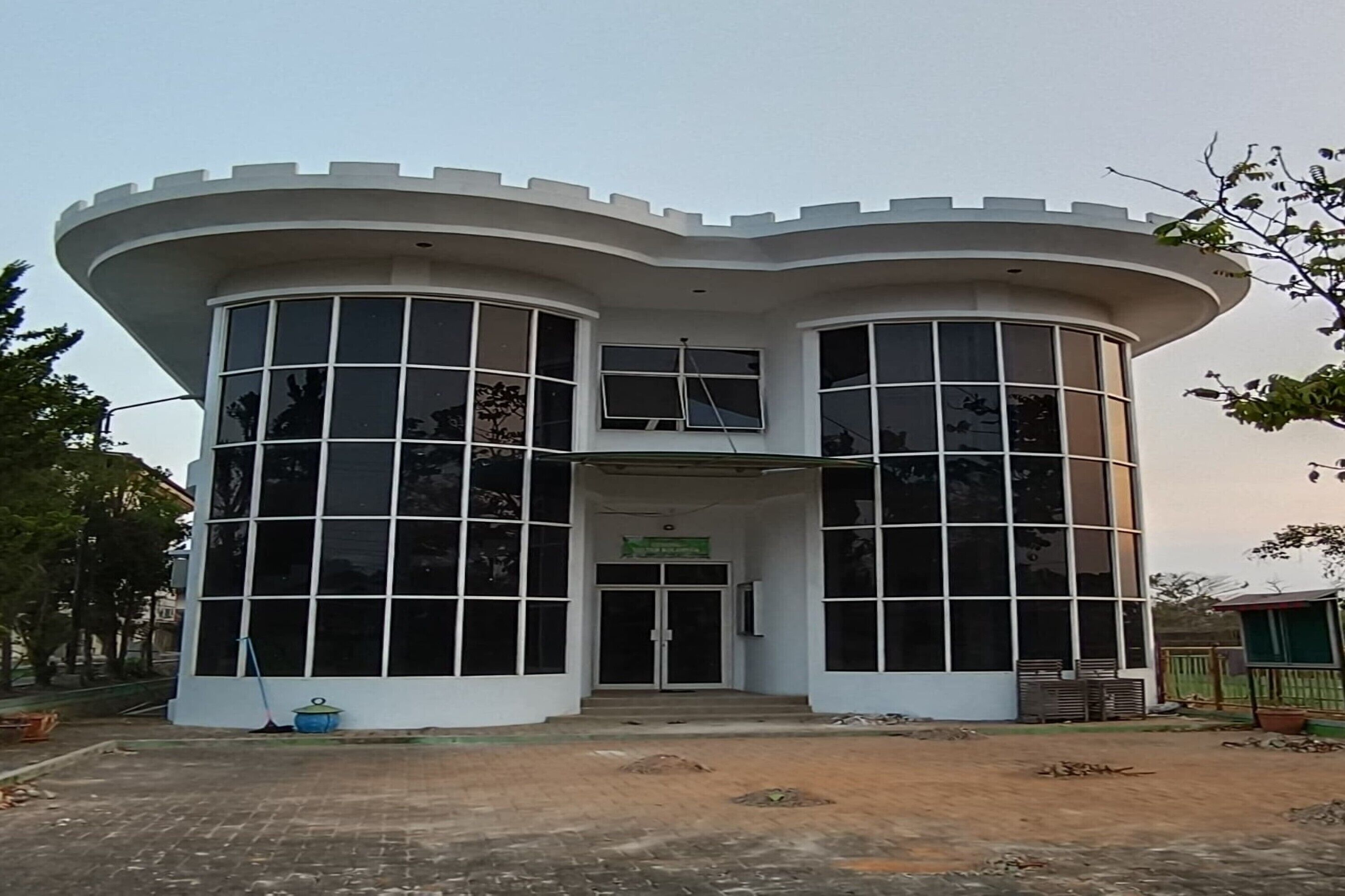 A modern building with a curved facade, large windows, and a central entrance.