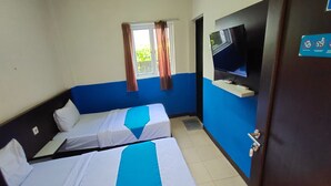 A hotel room with two single beds, a television on a stand, a window with curtains, and a door with a sign. - Hotel O Nilam Guest HouseNearYani Heahlerr (Marabahan)