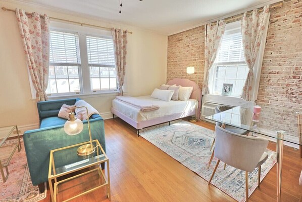 Relax in this classic bedroom with a large bed, comfortable seating area, and brick-patterned walls.