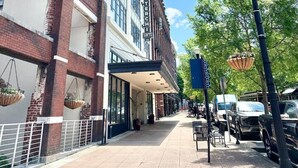A street view with a building labeled "STERCHI LOFTS" and a sidewalk with parked cars and street lamps. - Urban Retreat w/ Downtown Views (Knoxville)