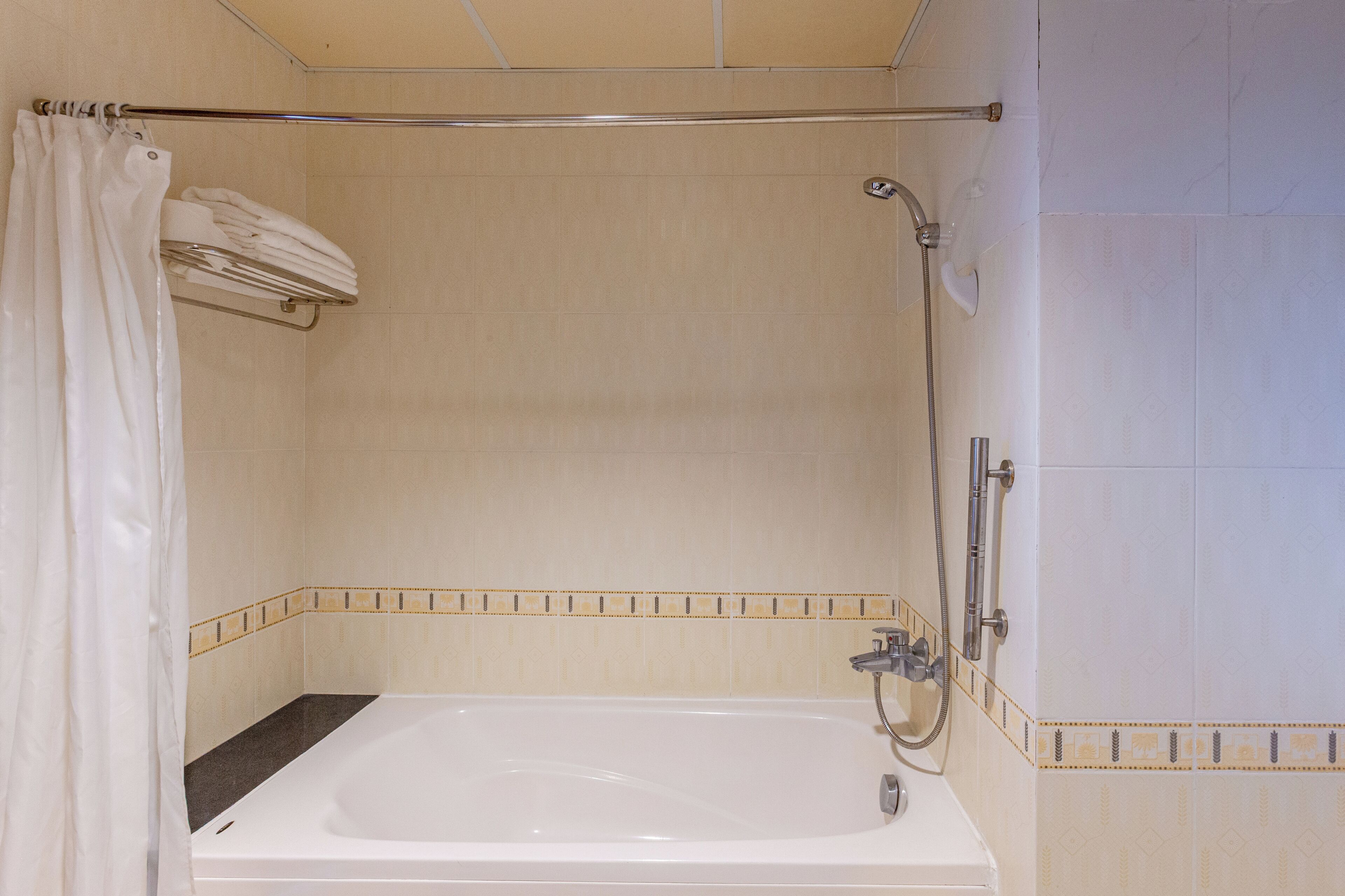 A bathroom with a bathtub, shower, and towel rack.