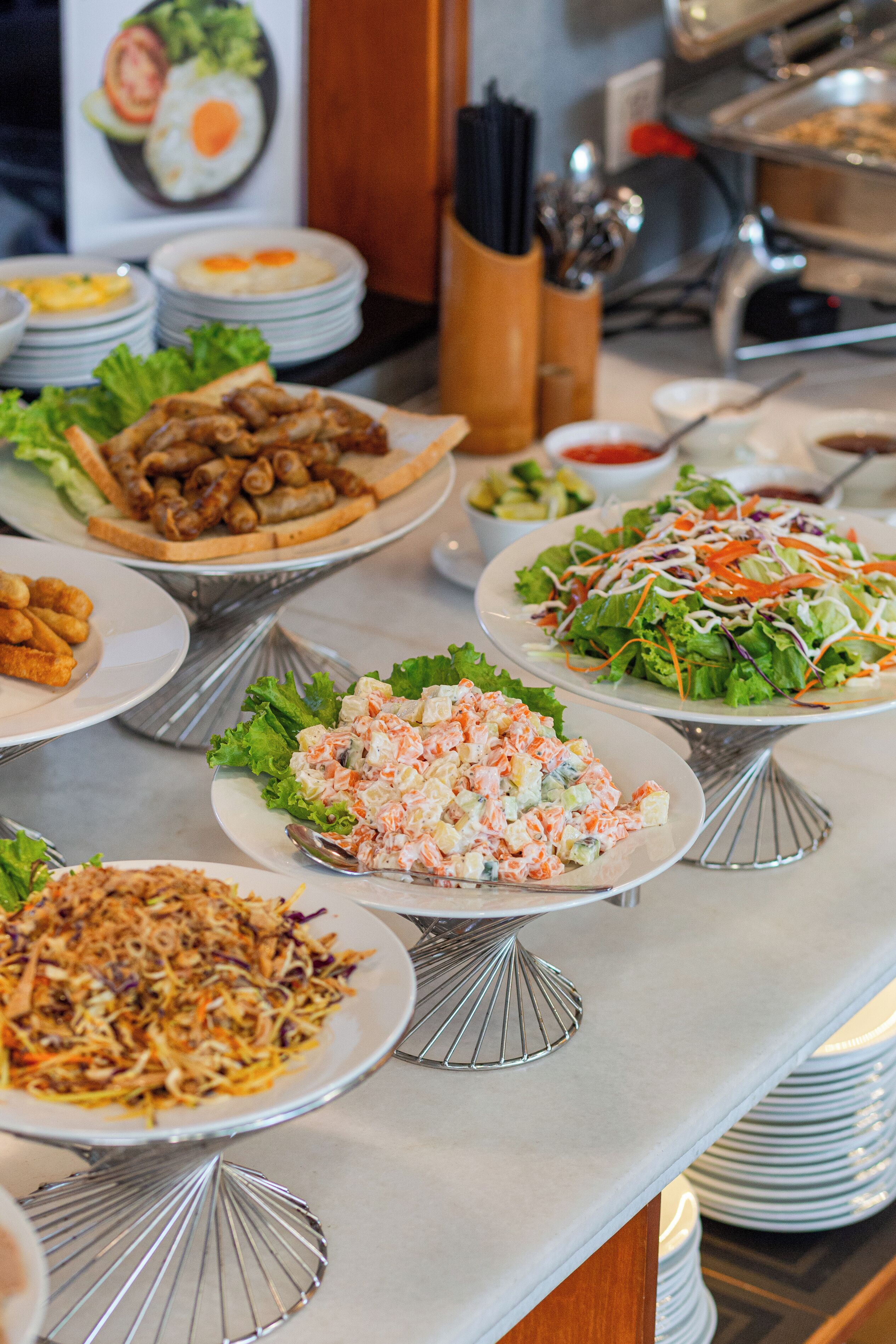 A buffet table with various dishes including salads, fried items, and a seafood dish.