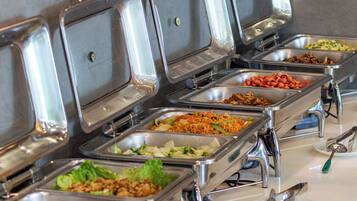 A buffet line with various food options, including salads, meats, and noodles.