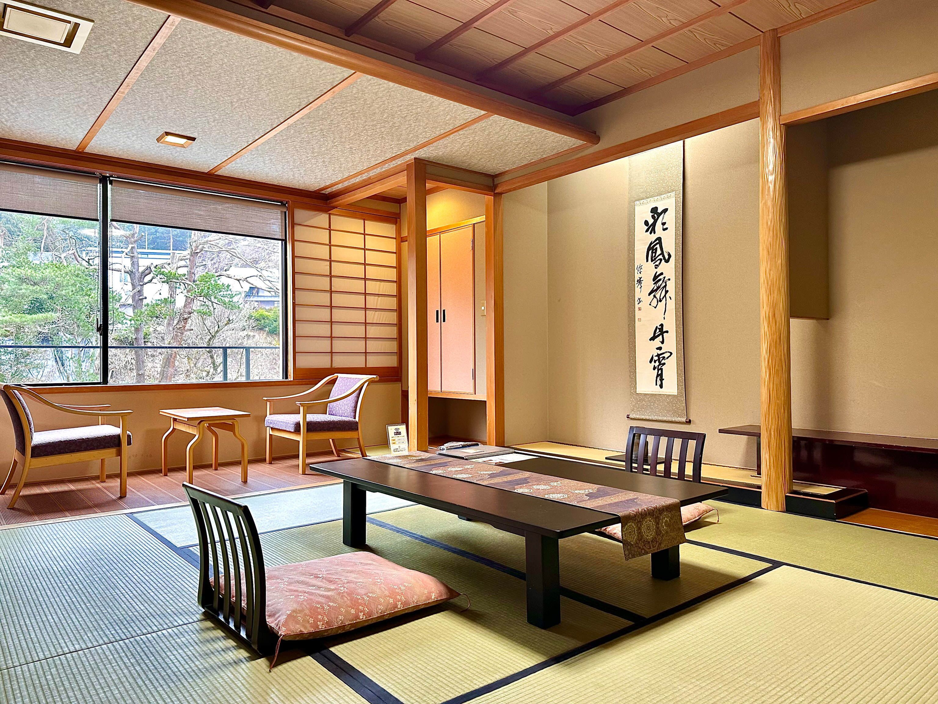 Una habitación tradicional japonesa con suelo de tatami, una mesa baja y puertas correderas.
