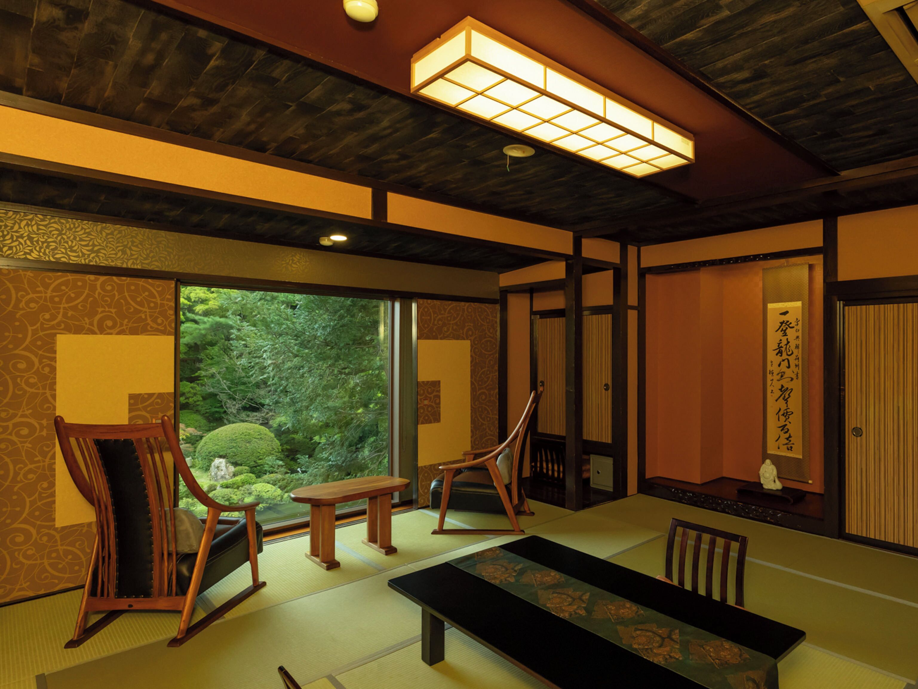 Una habitación japonesa tradicional con suelo de tatami, una mesa baja y puertas correderas que dan a un jardín.