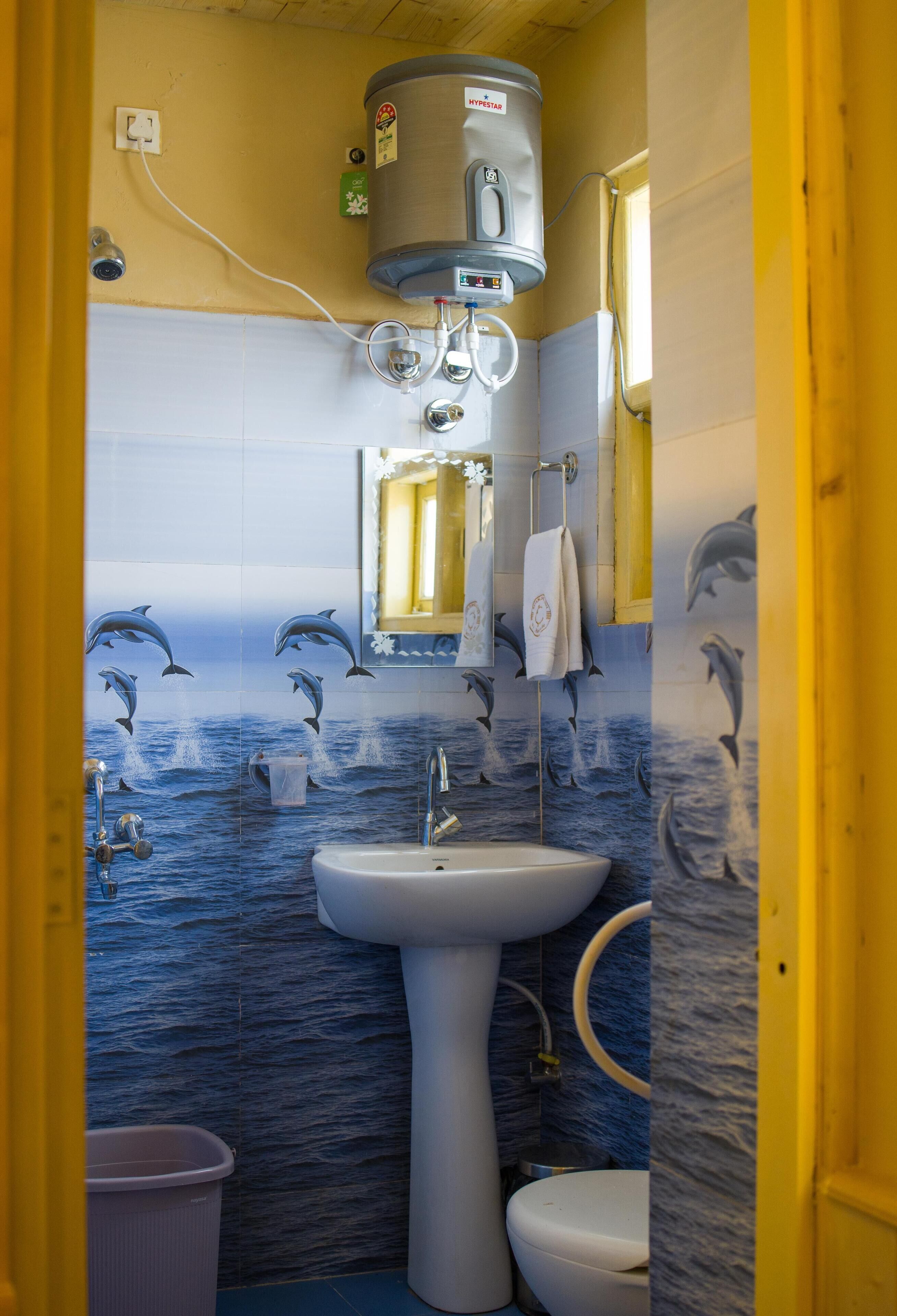 A bathroom with a white sink, a toilet, and a water heater.