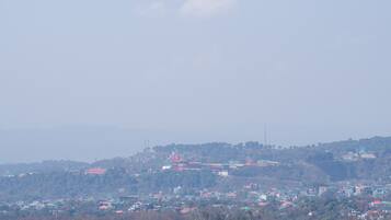 Vista panorámica de una ciudad con edificios dispersos en un paisaje montañoso.