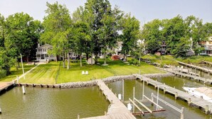 A marina with wooden docks and a grassy area with houses in the background. - Waterfront Home with Private Dock, Community Beach (Annapolis)