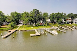 A lakeside property with multiple docks and a well-maintained lawn. - Waterfront Home with Private Dock, Community Beach (Annapolis)