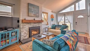 A cozy living room with a fireplace, a television, a sofa, and a bookshelf. - Waterfront Home with Private Dock, Community Beach (Annapolis)
