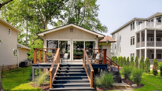 A two-story house with a front deck, a staircase, and a large sliding glass door. - Waterfront Home with Private Dock, Community Beach (Annapolis)