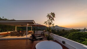 A rooftop terrace with a hot tub, outdoor seating, and a view of a mountain at sunset. - The Scoop Sea view Kamala 10km to Patong (Kamala)