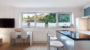 Una cocina moderna con un amplio ventanal, una televisión de pantalla plana y una zona de bar.