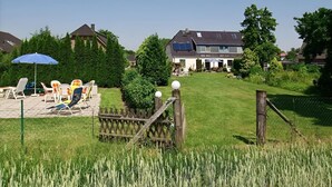 A residential area with a house, a lawn, and outdoor furniture. - Apartment "Zur Eule - Uhu" with Shared Garden & Wi-Fi (Satow OT Clausdorf)