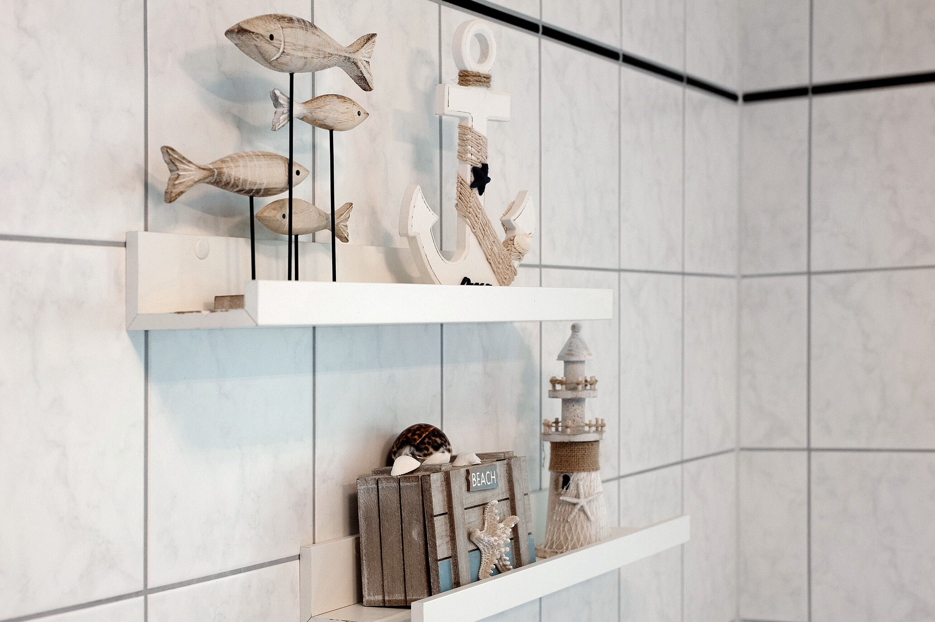 A wall with three wooden shelves displaying various decorative items.