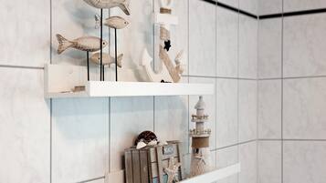 A wall with three wooden shelves displaying various decorative items.