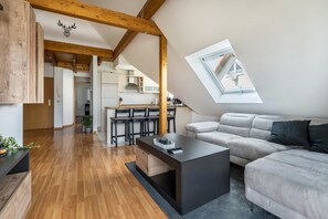 Un loft moderne comprenant un espace repas, une cuisine et une grande verrière.