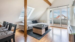 Un moderno loft con comedor, sofá, una mesa de centro y balcón con vistas.
