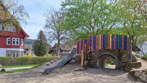 Une aire de jeux avec un toboggan et une structure d’escalade.