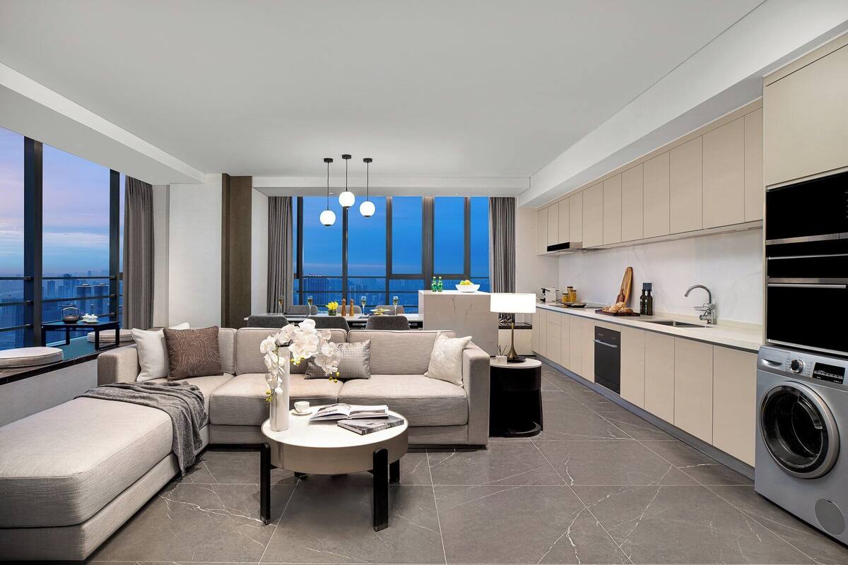A modern living room with a sofa, coffee table, and a view of the city.