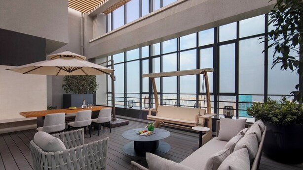 A modern rooftop lounge with a wooden table, chairs, and a sofa. - Ascott Tianfu CBD Chengdu (Chengdu)