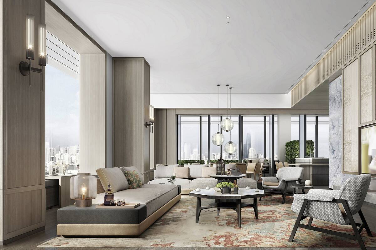 A spacious living room with a large sofa, a coffee table, and a television mounted on the wall.