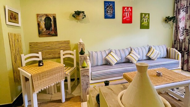 A living room with a sofa, chairs, a table, and a hanging light fixture. - Charming Getaway in Casablanca Maroc, Cozy Home with Thoughtful Amenities (Casablanca)