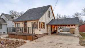 Einbungalow mit Veranda, einer kleinen Terrasse und einer Garage.