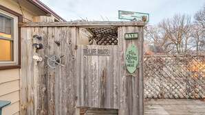 Eine rustikale Holzkonstruktion mit einem Schild, auf dem 'TOILET BOATS' und ein weiteres Schild mit 'BATHROOM' stehen.