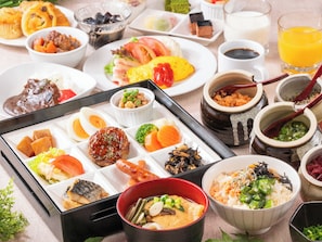 Diversos pratos e bebidas sobre uma mesa, incluindo sushi, sashimi e uma tigela de sopa.