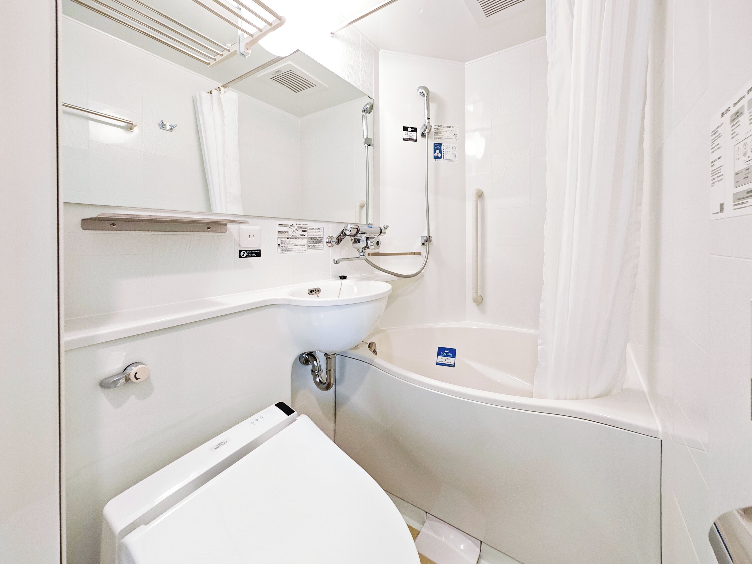 A modern bathroom with a toilet, sink, and bathtub.