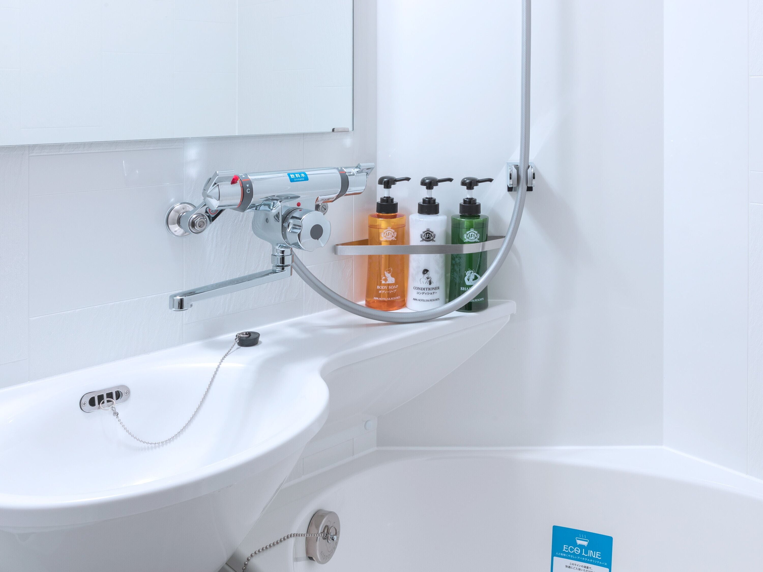 Une salle de bain avec un lavabo blanc, un miroir et une étagère contenant des articles de toilette.
