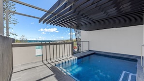 A swimming pool with a view of the ocean, a pergola, and a sign indicating 'Kings Edge'. - Kings Edge Unit 4 Kings Beach QLD (Kings Beach)