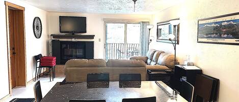 A living room with a television, sofa, and dining table.