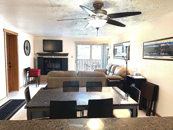 A living room with a television, sofa, and dining table.