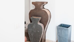 A room with a white wall, a large arched doorway, a dark wooden vase, and a blue trash bin. - Villa Michika by Elite Villas (Capri)