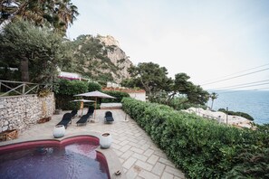 A pool area with lounge chairs, a small pool, and a view of the sea. - Villa Michika by Elite Villas (Capri)