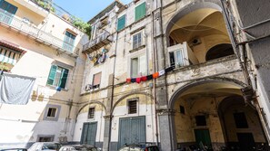 A narrow street with buildings featuring arched doorways and balconies.