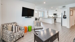A modern living room with a sofa, a coffee table, and a TV. - Convenient Anaheim Condo: Walk to Angel Stadium (Anaheim)