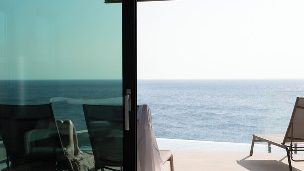 A balcony with two lounge chairs facing the ocean. - Casa Tarrha - Beachside Retreat with Private Heated Pool (Chania Town  Livadia)