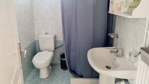 Un baño con inodoro, lavabo y cortina de ducha.