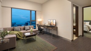 A modern hotel room with a large window, a desk, a comfortable sofa, and a bed. - Citadines Nanhai Foshan (Foshan)